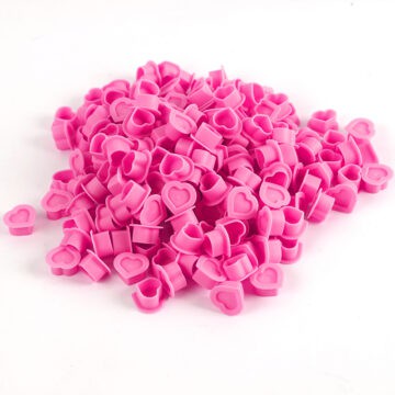 Pink silicone heart-shaped ink cups for tattoo supplies.